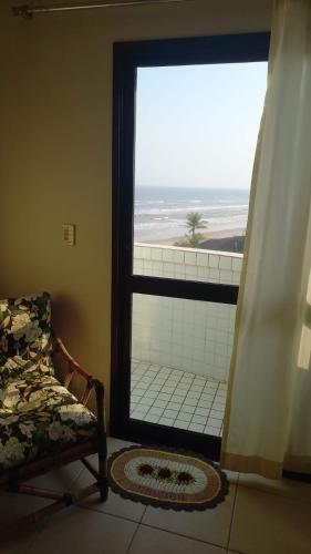 a room with a window with a view of the beach at Apartamento frente ao mar!!! in Itanhaém