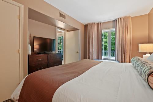 ein Schlafzimmer mit großem Bett und Flachbildfernseher in der Unterkunft King Bed, Balcony, Pool, Hot Tub, Sauna in Edgar