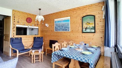 une salle à manger avec une table et des chaises bleues dans l'établissement Résidence Aravis - Appartement lumineux & confortable · Accès direct aux pistes · Balcon MAE-3034, aux Menuires