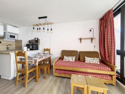 Cette petite chambre comprend un canapé et une table. dans l'établissement Résidence Cote Brune - Studio lumineux · Accès direct aux pistes · Balcon MAE-3114, aux Menuires
