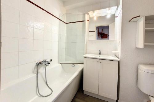une salle de bain blanche avec une baignoire et un lavabo dans l'établissement Résidence Median - Studio lumineux · Proche des pistes · Balcon MAE-3144, aux Menuires