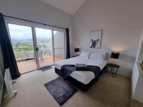 a bedroom with a large bed and a large window at Cascades 15 - Amazing Lake Views l Spa Bath l Split Level Apt l Central Location l Wi-Fi in Jindabyne