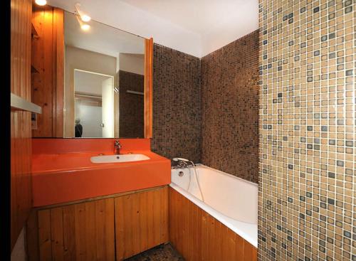 une salle de bain avec un lavabo, une baignoire et un miroir dans l'établissement Résidence Chaviere - Studio agréable · Ski au pieds · Balcon MAE-3154, aux Menuires