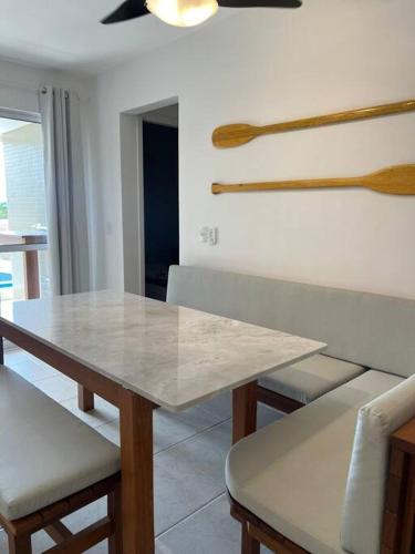 a dining room with a table and some wooden utensils at Apartamento pé na areia in Matinhos