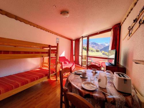 una stanza con un tavolo e un letto a castello di Résidence Grande Masse - Studio lumieux · Accès direct aux pistes · Balcon MAE-3324 a Les Menuires