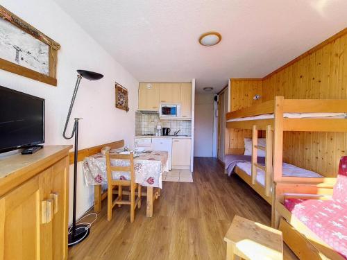 Cette petite chambre comprend des lits superposés et une cuisine. dans l'établissement Résidence Grande Masse - Studio pour 3 Personnes 354, aux Menuires