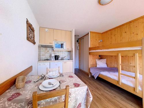 Camera con tavolo da pranzo e letto a castello. di Résidence Grande Masse - Studio lumineux · Départ et retour skis aux pieds · Balcon MAE-3354 a Les Menuires