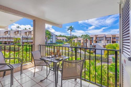 a balcony with a table and chairs and a view at Rear Ocean View 2 Bedroom Single Level Condo at Kamaole Sands 9-305 in Wailea