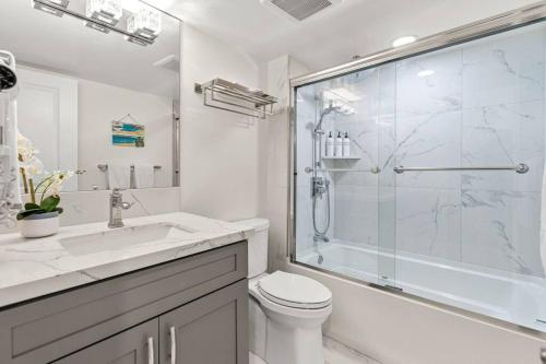 a bathroom with a shower and a toilet and a sink at Rear Ocean View 2 Bedroom Single Level Condo at Kamaole Sands 9-305 in Wailea