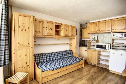 un canapé dans une cuisine avec des placards en bois dans l'établissement Résidence Dorons - Studio lumineux · Centre station · Balcon MAE-3414, aux Menuires