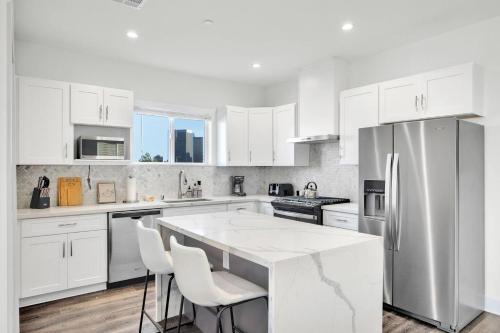 a kitchen with white cabinets and a large kitchen island at Fresh & New Downtown LA Condo! in Los Angeles