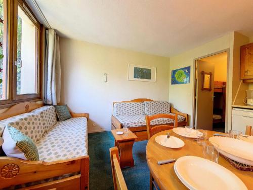 un salon avec un canapé et une table dans l'établissement Résidence Boedette A - Studio classique · Départ et retour skis aux pieds MAE-3564, aux Menuires