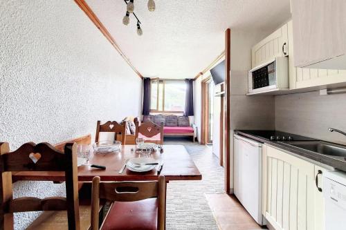 une cuisine et une salle à manger avec une table et des chaises dans l'établissement Résidence Median - Appartement confortable · Proche des pistes · Balcon MAE-3584, aux Menuires
