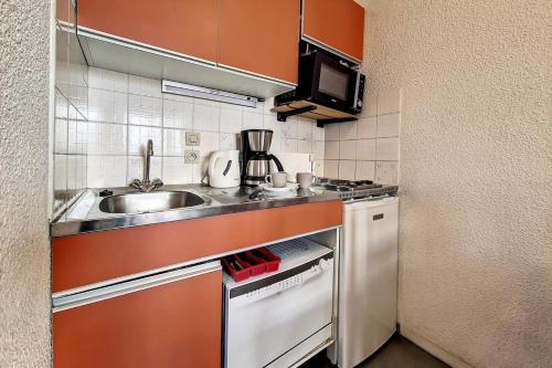 une petite cuisine avec un évier et une cuisinière dans l'établissement Résidence Carlines I - Studio classique · Au pieds des pistes · Balcon MAE-3664, aux Menuires