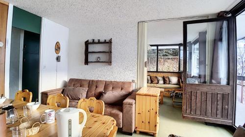un salon avec un canapé et une table dans l'établissement Résidence Aravis - Appartement spacieux · Départ et retour ski aux pieds · Balcon vue montagnes MAE-3704, aux Menuires