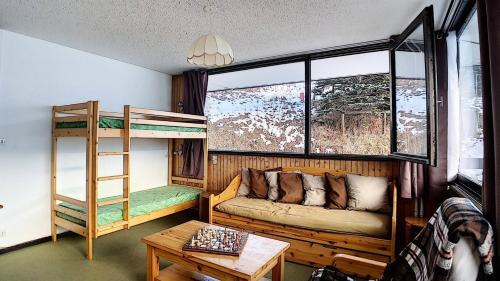 - un salon avec un canapé et des lits superposés dans l'établissement Résidence Aravis - Appartement spacieux · Départ et retour ski aux pieds · Balcon vue montagnes MAE-3704, aux Menuires