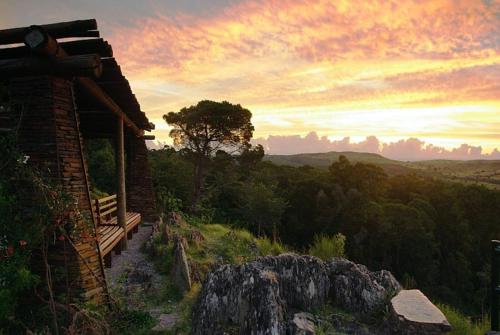 a house on a hill with a sunset in the background at Alquilo casa en las Sierras de Minas "VIEJO RANCHO" in Minas