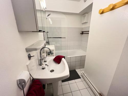 La salle de bains blanche est pourvue d'un lavabo et d'une baignoire. dans l'établissement Résidence Bez - Appartement· Cœur de station · Parking privé & casier à skis MAE-3264, à La Salle Les Alpes