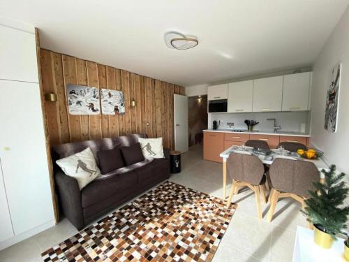 un salon avec un canapé et une table et une cuisine dans l'établissement Résidence Bez - Studio · Cœur de station · Parking collectif & casier à skis MAE-9064, à La Salle Les Alpes