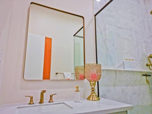 a bathroom with a sink with a mirror and a lamp at Villa Topenga Ocean View Luxury 2 Bedroom in Content