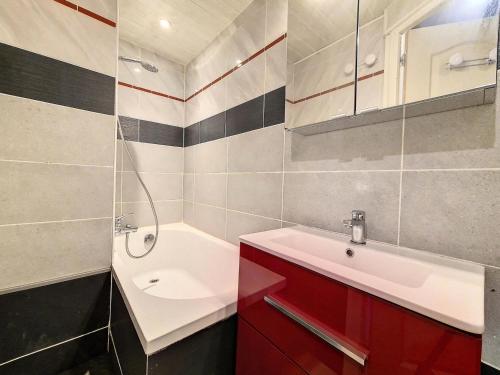 La salle de bains est pourvue d'une armoire rouge et d'un lavabo. dans l'établissement Résidence Tougnette - Appartement lumineux · Pied des pistes · Vue exceptionnelle MAE-0804, aux Menuires