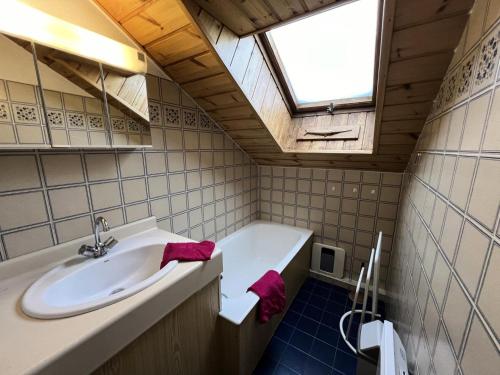 La salle de bains est pourvue d'un lavabo, d'une baignoire et d'une fenêtre. dans l'établissement Résidence Gardiole 1 - Appartement · Proche des pistes · Vue montagne MAE-3761, au Monêtier-les-Bains
