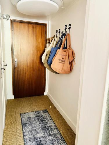 un couloir avec une porte avec des sacs sur le mur dans l'établissement Résidence La Meije - Studio· Centre station/cœur de station · Vue pistes MAE-9071, à La Salle Les Alpes