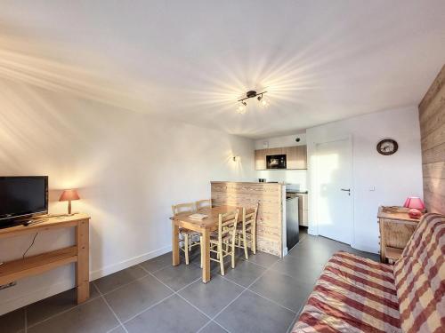 un salon avec une table et une cuisine dans l'établissement Résidence Balcons De Tarentaise Bat B - 