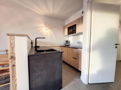 une petite cuisine avec un évier et un réfrigérateur dans l'établissement Résidence Balcons De Tarentaise Bat B - 