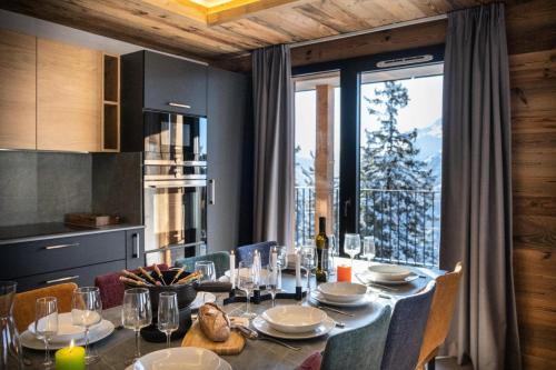 une salle à manger avec une table et une grande fenêtre dans l'établissement Résidence OrÉe Du Bois - APPARTEMENT N°4 L'OREE DU BOIS MAE-9651, à Montvalezan