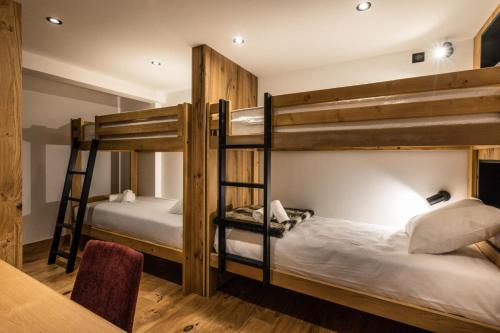 Ce dortoir comprend 2 lits superposés et une table. dans l'établissement Résidence OrÉe Du Bois - APPARTEMENT N°4 L'OREE DU BOIS MAE-9651, à Montvalezan