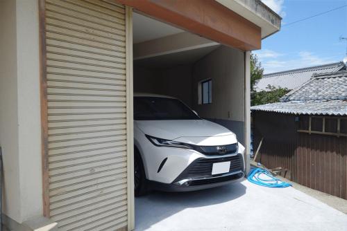 a white car is parked in a garage at いろどり荘 ドッグラン併設 露天風呂付き in Inokuchi