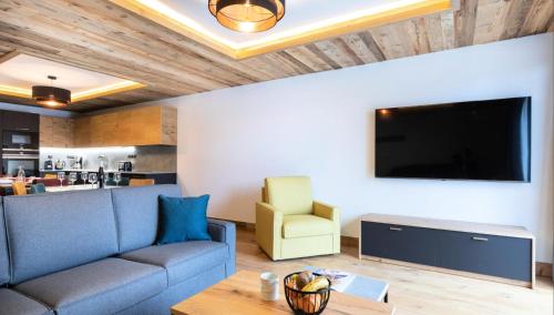 un salon avec un canapé et une télévision à écran plat dans l'établissement Résidence OrÉe Du Bois - APPARTEMENT N°1 L'OREE DU BOIS MAE-9681, à Montvalezan
