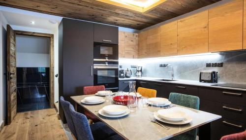 une cuisine avec une table avec des chaises et une salle à manger dans l'établissement Résidence OrÉe Du Bois - APPARTEMENT N°1 L'OREE DU BOIS MAE-9681, à Montvalezan