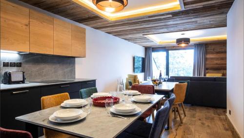 une cuisine et une salle à manger avec une table et des chaises dans l'établissement Résidence OrÉe Du Bois - APPARTEMENT N°3 L'OREE DU BOIS MAE-9711, à Montvalezan