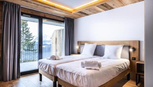 une chambre avec un grand lit et une grande fenêtre dans l'établissement Résidence OrÉe Du Bois - APPARTEMENT N°3 L'OREE DU BOIS MAE-9711, à Montvalezan