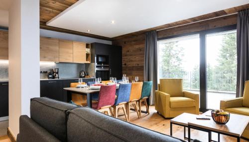 Il dispose d'une cuisine et d'un salon avec un canapé et des chaises. dans l'établissement Résidence OrÉe Du Bois - APPARTEMENT N°2 L'OREE DU BOIS MAE-9721, à Montvalezan