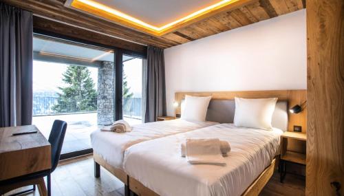 une chambre avec un lit, un bureau et une fenêtre dans l'établissement Résidence OrÉe Du Bois - APPARTEMENT N°2 L'OREE DU BOIS MAE-9721, à Montvalezan