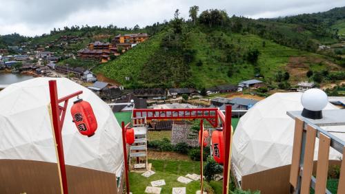 two white domes on top of a building with a hill at รักไทยโฮมสเตย์ in Ban Rak Thai