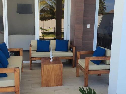 a porch with chairs and a table with blue pillows at Casa Vacacional Almendros in El Conacaste