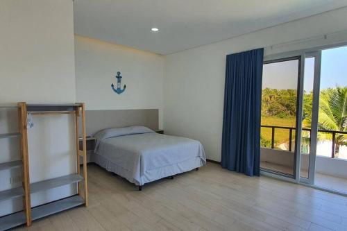 a bedroom with a bed and a large window at Casa Vacacional Almendros in El Conacaste