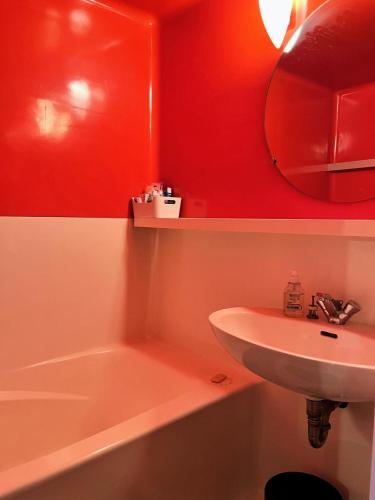 une salle de bain avec un lavabo, une baignoire et un miroir dans l'établissement Résidence Belles Challes - Studio 4 personnes Belles Challes MAE-7531, à Arc 1800