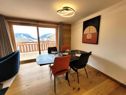 une salle à manger avec une table et des chaises et une fenêtre dans l'établissement Résidence Le Clos D'arsene - Appartement lumineux avec terrasse MAE-5601, aux Gets