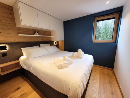 une chambre avec un grand lit avec des serviettes dessus dans l'établissement Résidence Le Clos D'arsene - Appartement lumineux avec terrasse MAE-5601, aux Gets