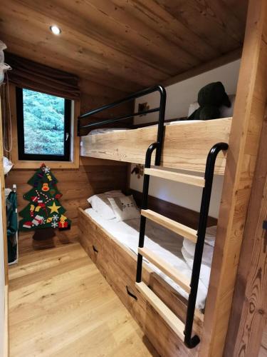 Cette cabine comprend des lits superposés et un arbre de Noël. dans l'établissement Résidence OrÉe Des Pistes - Appartement ski aux pieds au centre de la station ! MAE-2371, aux Gets