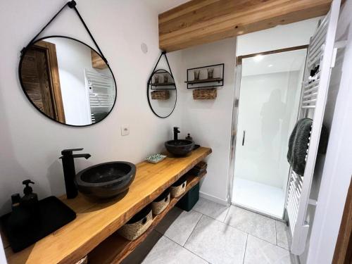 une salle de bain avec deux lavabos et un miroir dans l'établissement Résidence Ambrocella - Appartement de charme sous les toits MAE-2301, aux Gets