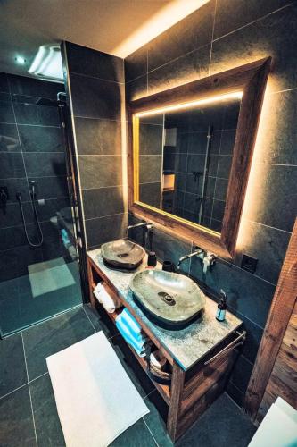 une salle de bain avec un lavabo et une douche avec un miroir dans l'établissement Chalet Nyumbani - Exceptionnel : Chalet prestigieux, belles finitions, proche pistes de ski MAE-2361, aux Gets
