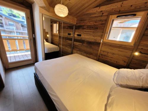 une chambre avec un lit dans une pièce avec une fenêtre dans l'établissement Résidence Le Confidentiel - Bel appartement 4 personnes au centre du village MAE-2391, aux Gets