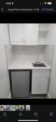 a kitchen with white cabinets and a sink at LYZ Miami Airport in Miami