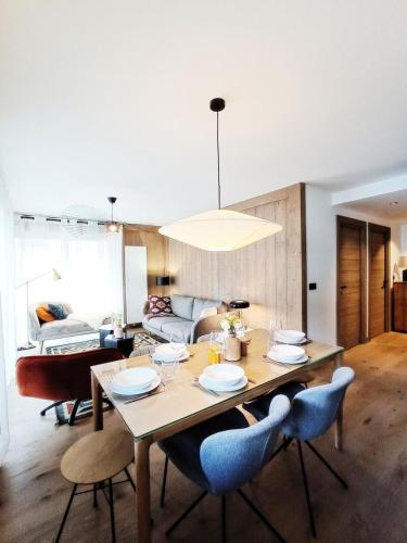 une salle à manger avec une table, des chaises et un canapé dans l'établissement Résidence Le Vieux ChÊne - Appartement avec double balcon au coeur du village MAE-2411, aux Gets